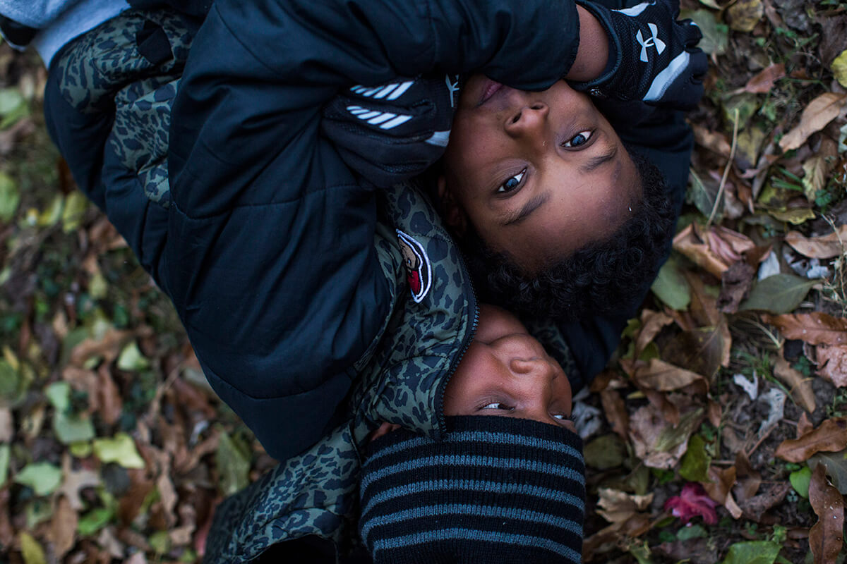 Young men involved in the Village wrestle in the leaves on a December day in Ferguson, Mo. 
