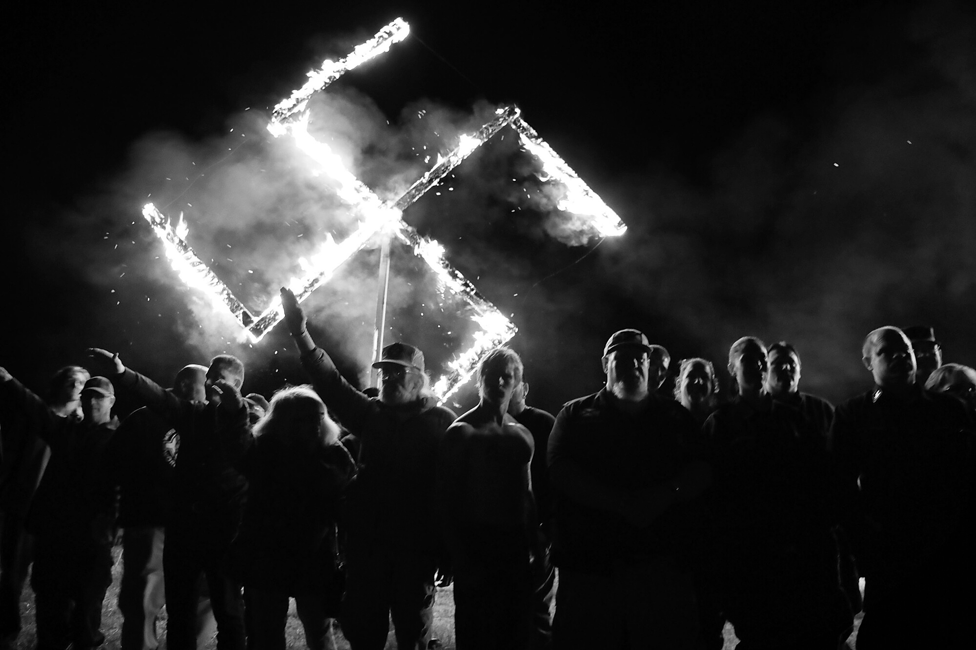 Members of the National Socialist Movement, one of the largest neo-Nazi groups in the US, hold a swastika burning after a rally in April 2018 in Draketown, Ga. From the White House, Donald Trump ignored the danger of white supremacist groups, and equivocated on the threat they posed to American values and the homeland.Trump later went on to foment an insurrection and attempted coup with the support of white supremacist groups.