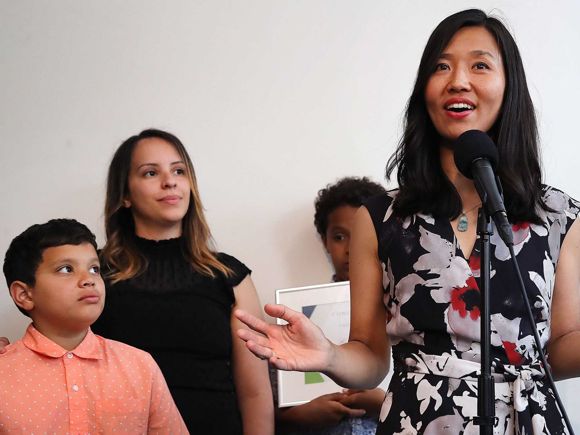 Dorchester-06/14//2023 Boston Mayor Michelle Wu speaks next to new homeowner, Gisselle Jimenez as her son, Elias looks on during a ceremonial home closing at a real estate company in Dorchester. Jimenez was able to close on a home through the Section 8 to Homeownership program, part of Boston’s One+BostonHomebuyer program. John Tlumacki/Globe Staff (metro)