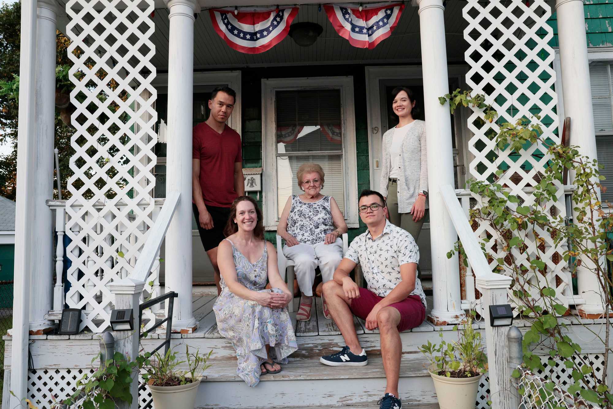 Mary Logue, 90, on the front stoop of the Dartmouth Street house, surrounded by four of her six grandkids, clockwise from top left: Brendan, Amanda, James, and Catherine.
