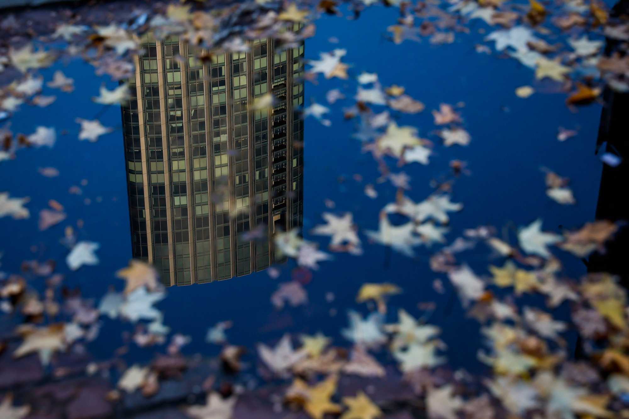 One Dalton was reflected in a puddle on Massachusetts Avenue. With hundreds of expensive condos hitting the Boston market and more in the pipeline, there is a housing crisis on the ground, but a surplus in the sky.