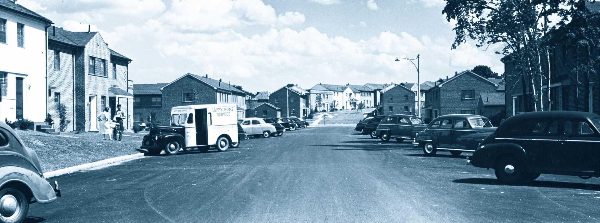 A view down Gerry Road as a neighbor spoke with a deliveryman from Happy Home Service at Hancock Village in Brookline, which was built in the 1940s. 