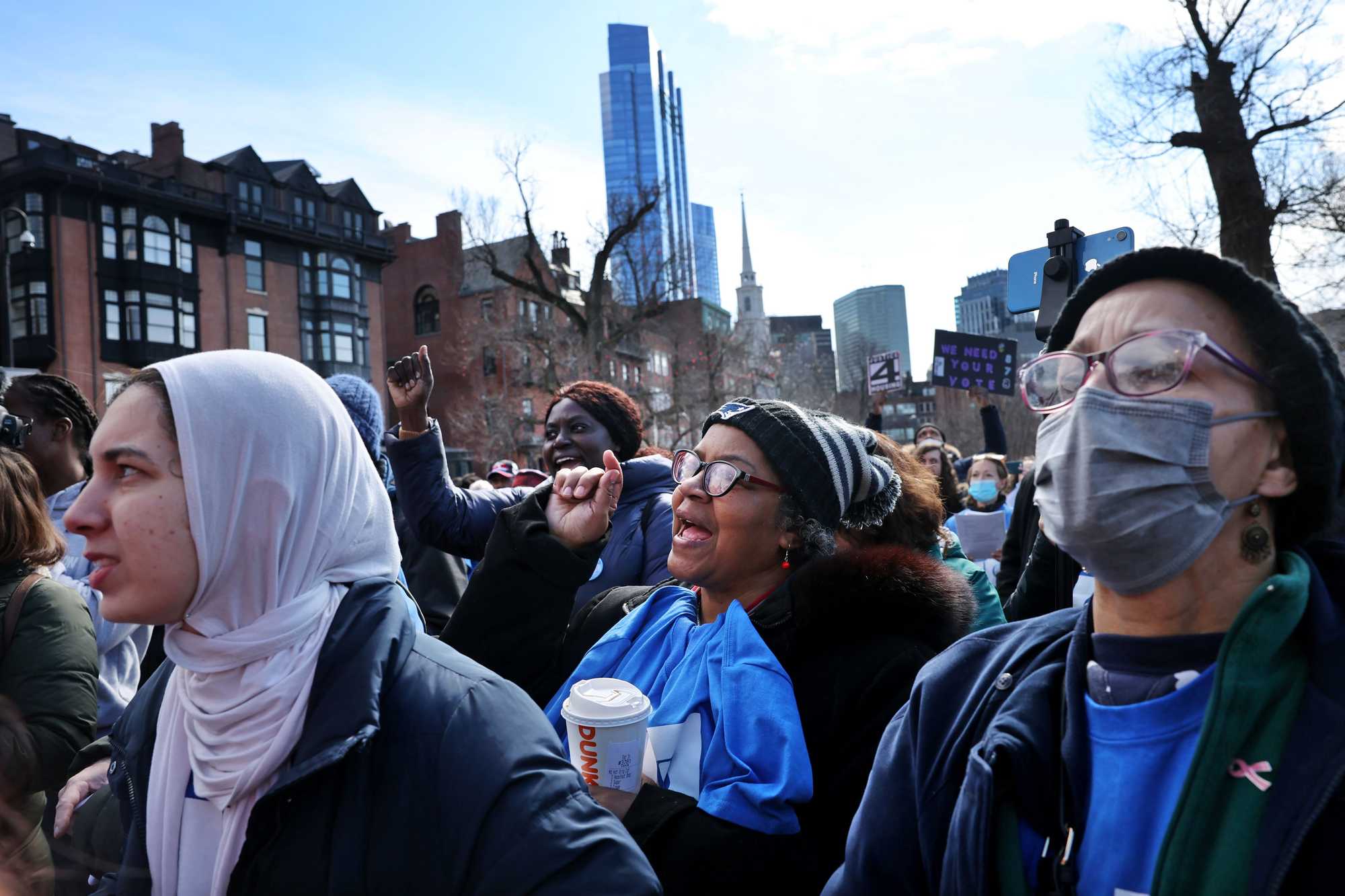 Boston, MA - 3/16/2023: Michele (cq) Frazier, center, and Renee Spencer, right, both of Wellesley, cheer during a rally held by the Greater Boston Interfaith Organization outside the State House  in Boston, MA on March 16, 2023. The GBIO held the event to urge state officials "to face the housing crisis head-on." (Craig F. Walker/Globe Staff) (Organizers say they plan to bring more than 300 people and that clergy members collectively feel "we have faith, but we have lost our patience!" The GBIO agenda includes $184 million in the fiscal 2024 budget for operating funds for housing authorities, a five-year housing bond bill authorizing $8.5 billion in capital funds to sustain public housing facilities and work off the accumulated backlog of deferred capital projects, and passing statewide enabling legislation for a local option to collect real estate transfer fees to increase funding for affordable housing. LivableStreets, through its Great Neighborhoods Network, has supported housing justice and reform and is encouraging people to attend.....State House steps) 