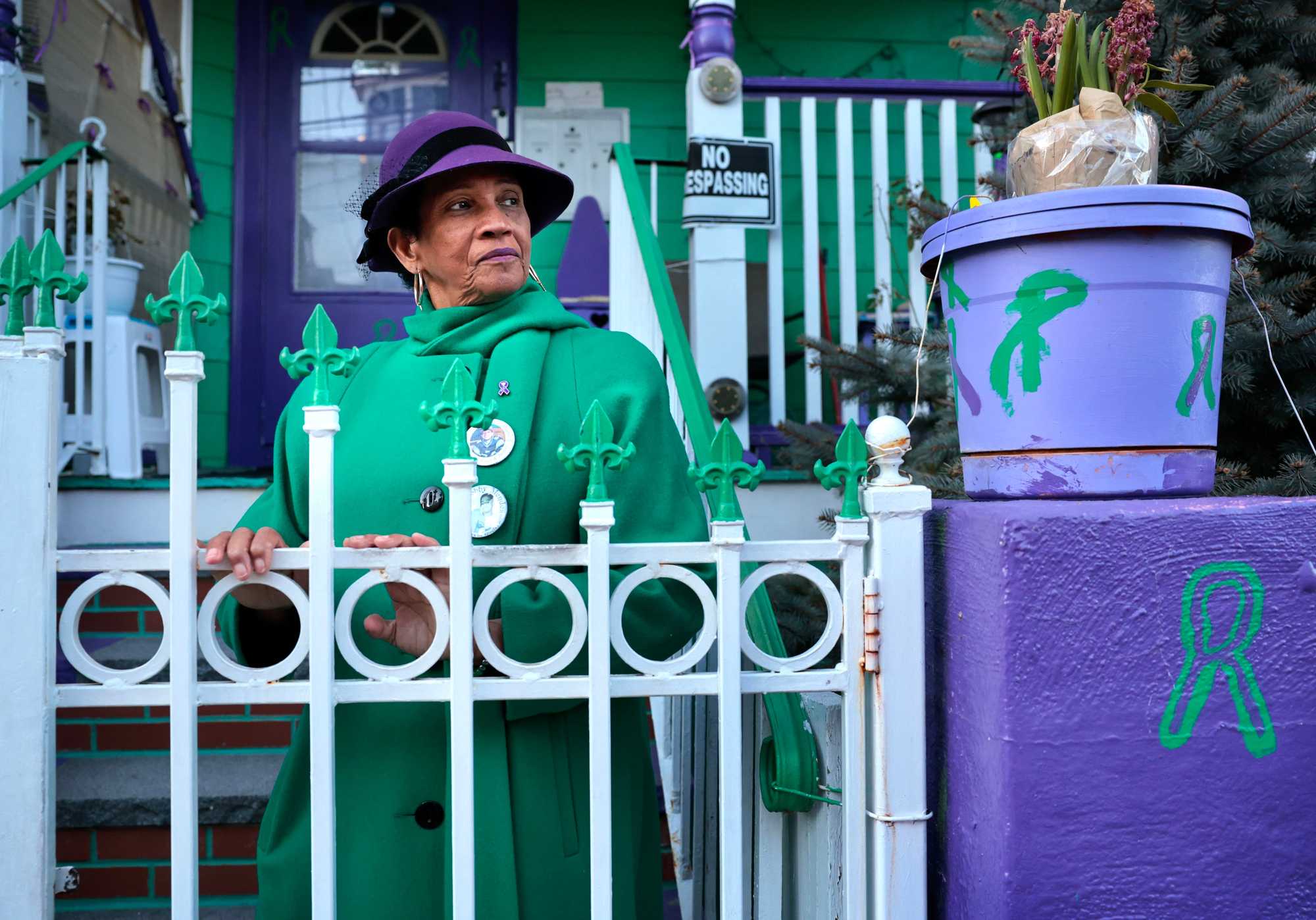 Isaura Mendes, a peace activist, stood outside her home while reflecting on the murders of her sons, Bobby and Matthew, in her Dorchester neighborhood. She painted her house green and purple because the colors to her represent courage and peace. 