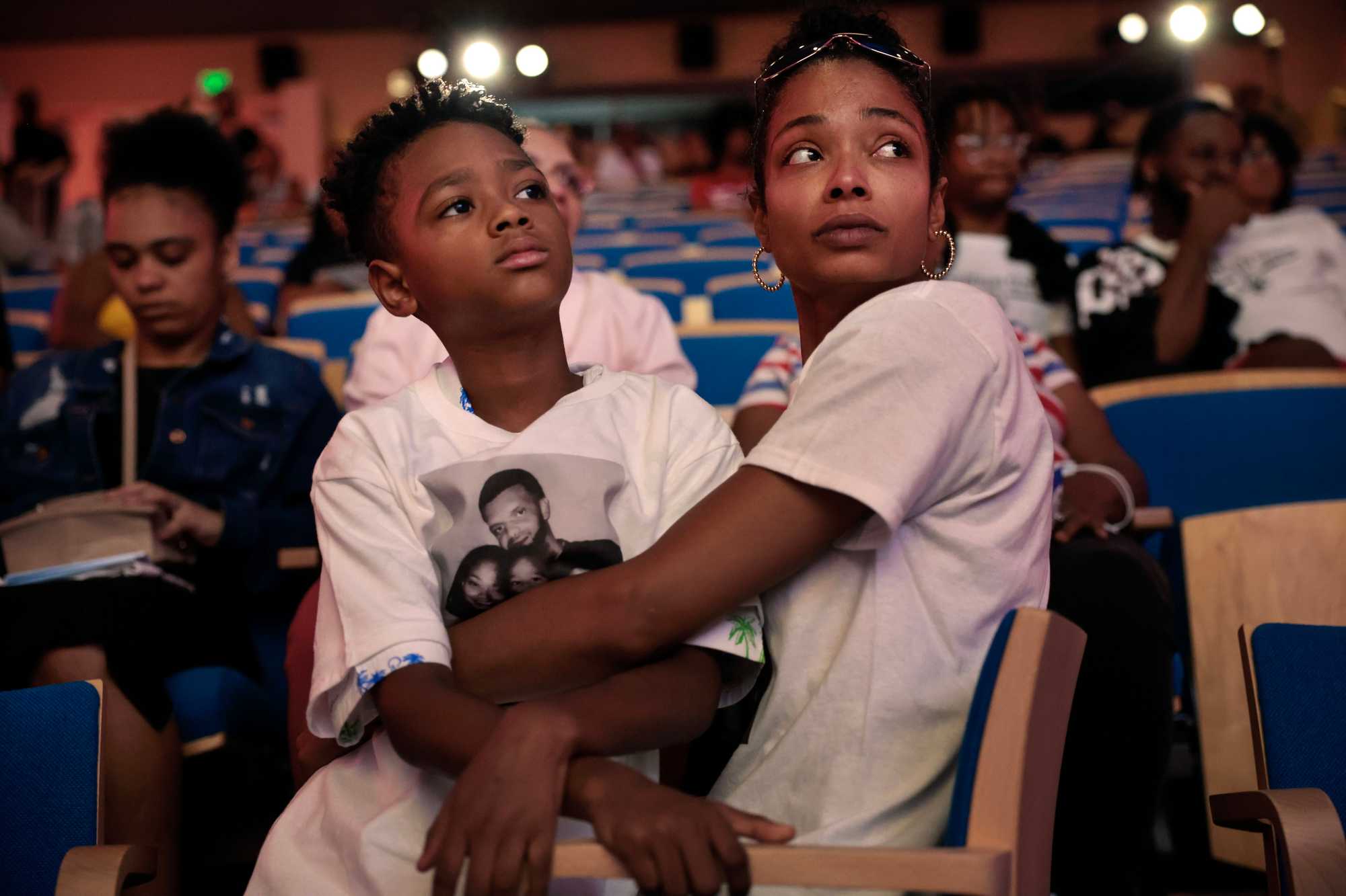 Deanna Neal Fernandes sat with her son, Camden, 10, during the "Tudo Djunto - All Together We Can Stop Violence" community forum at the Boston Public Library. Her husband, Odair Fernandes, joined the conference by video feed from MCI-Norfolk. 