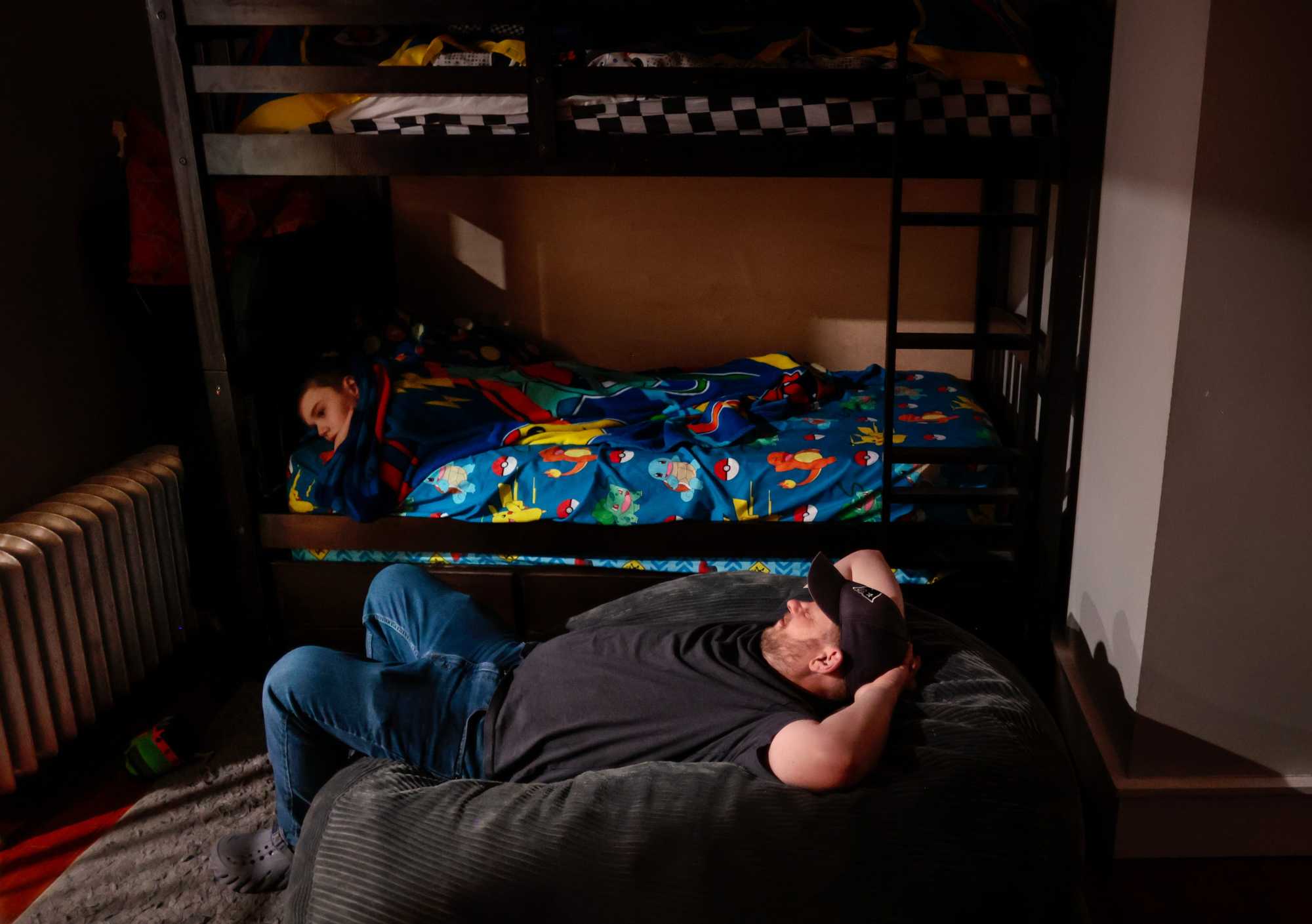 Phil Corriveau rested in a beanbag chair waiting for Dante to fall asleep at their home in Wakefield in February. Dante's mother, Jen, said her son will not fall asleep if he is left alone. Phil often falls asleep himself while waiting.