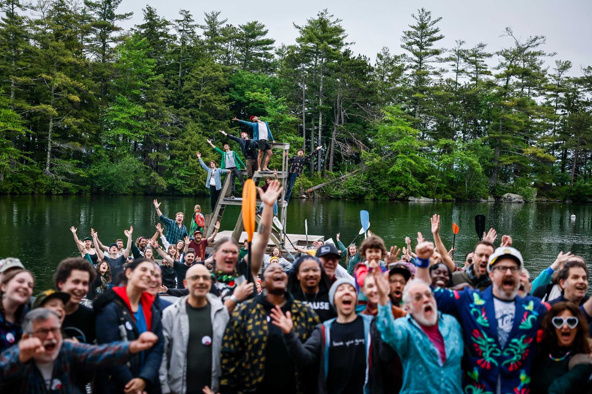 Campers gather on the dock for a group photo, with some participants taking the plunge into Lake Winnipesaukee's cold waters.