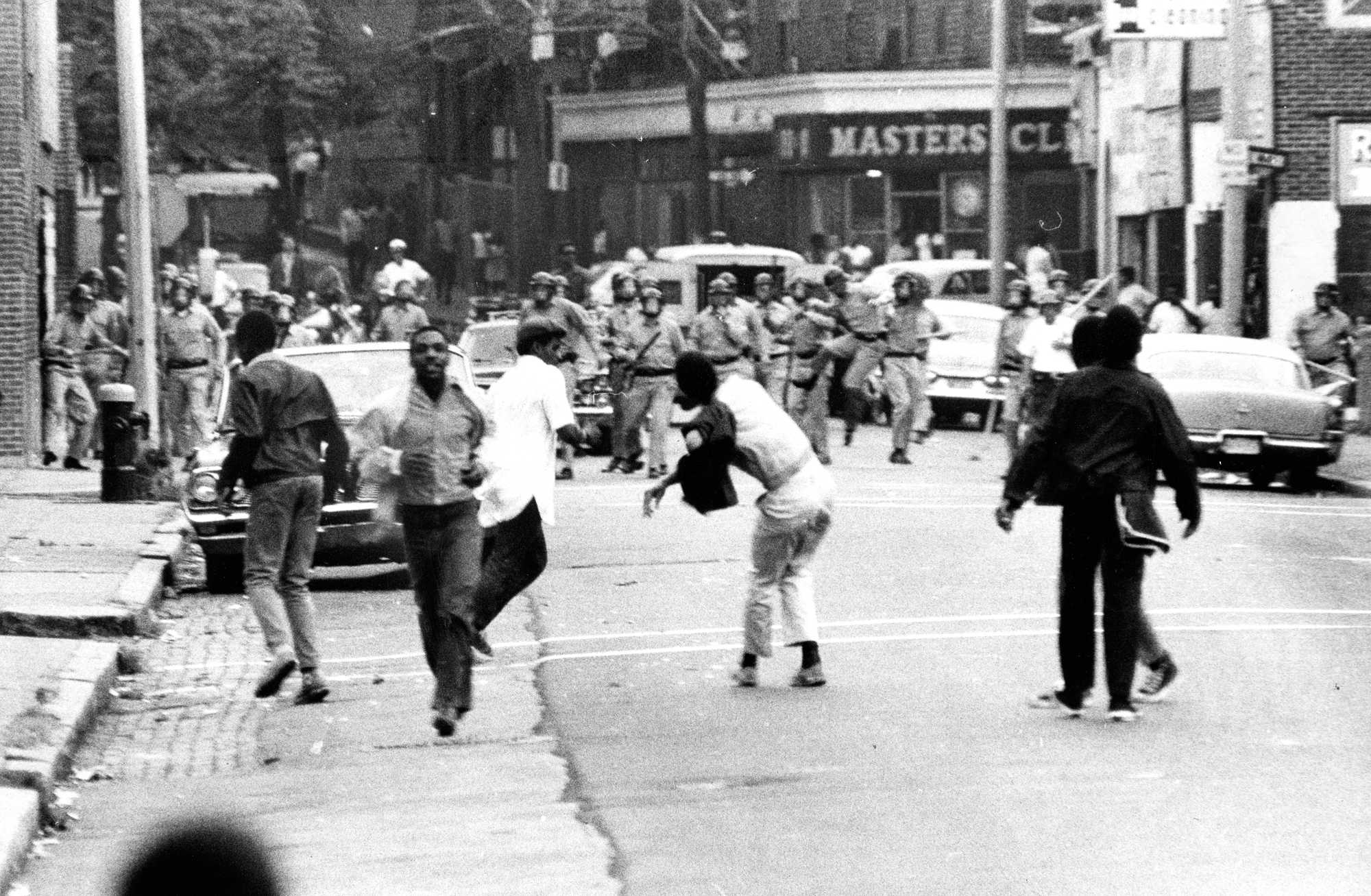 A demonstrator throws a rock toward a group of Boston police officers on Sept. 25, 1968, on Eustis Street in Roxbury. The unrest picked up quickly after the 1968 school year began.