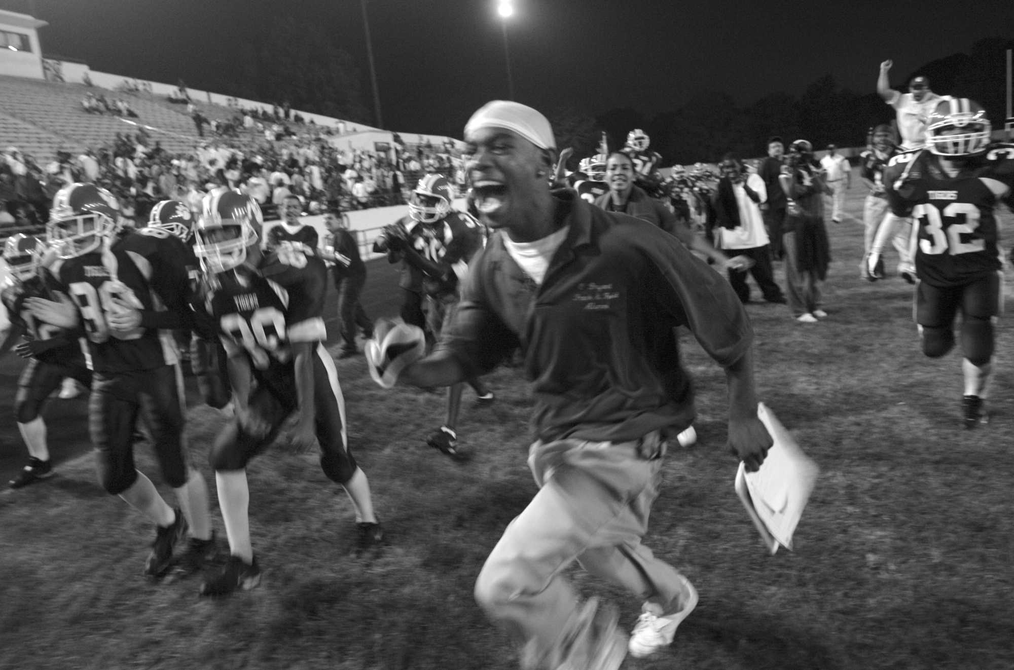 The O'Bryant sideline rejoices during a second-half play in its win over South Boston Education Complex in the first Friday night game at White Stadium in decades.