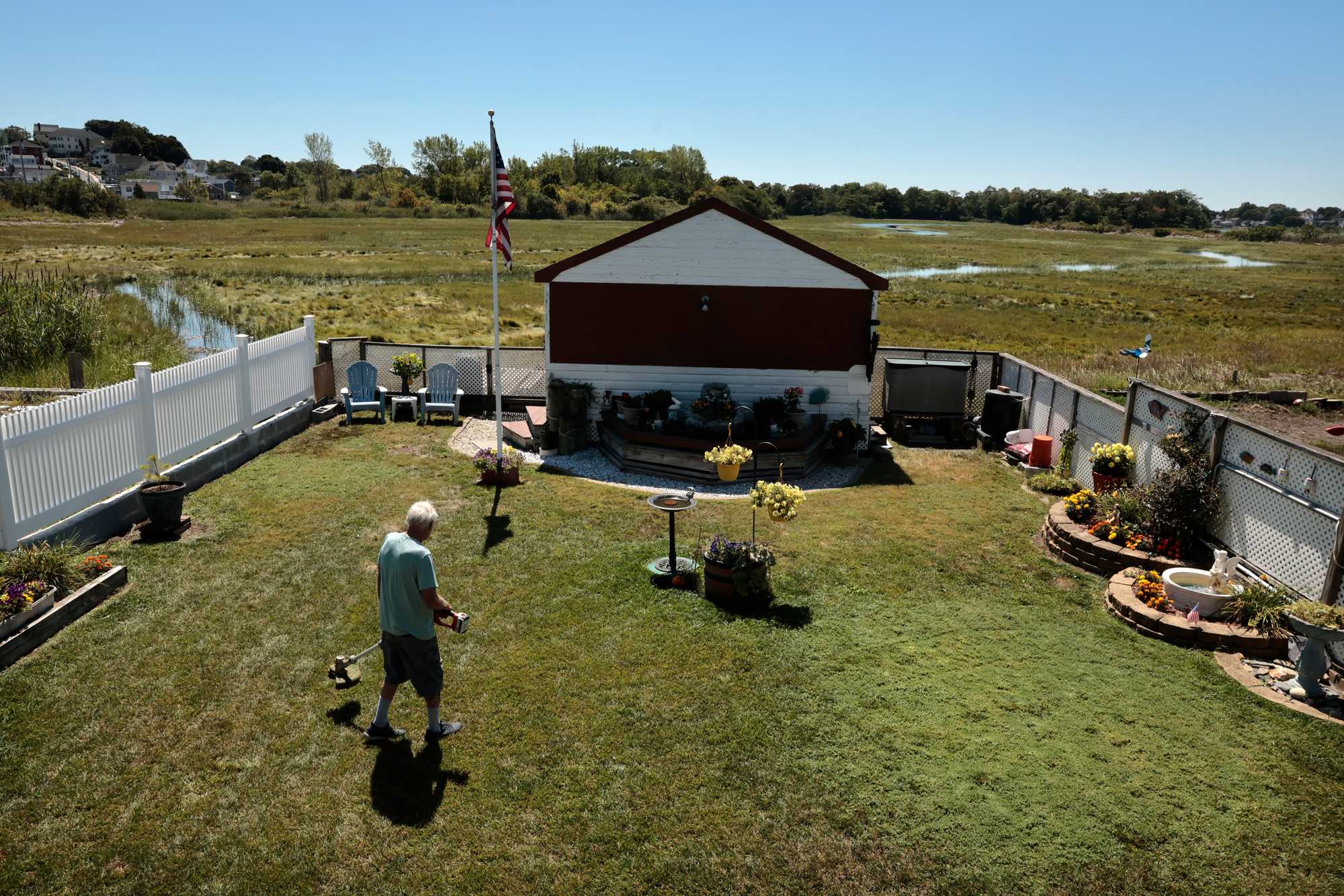 Joe LaVigueur worked in his yard in Revere, where his home on Pearl Avenue is prone to flooding due the neighboring marsh and nearby ocean.