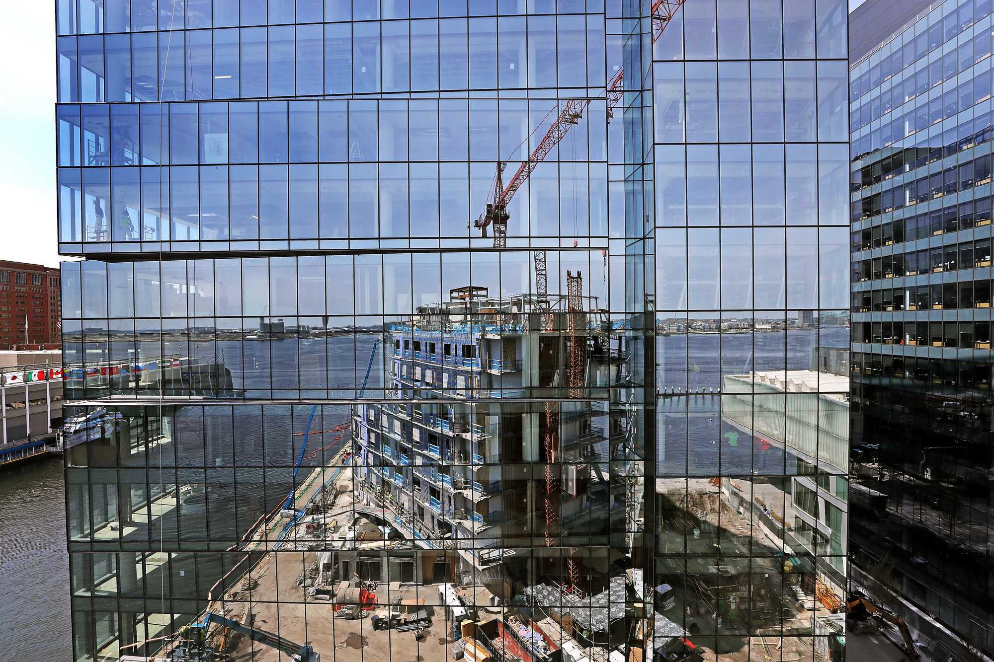 An under-construction condo building on Pier 4, reflected in the windows of a new office building, in 2018.