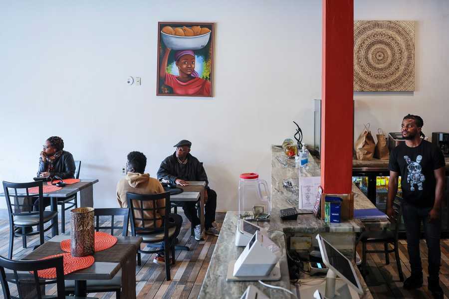 BOSTON, MA - 4/20/2024 Kelly Mazile, right, looks out the window as he waits for customers to come in to Divine Merci, a Haitian restaurant in Mattapan owned by Marie Dessain and Jean Nelson. The restaurant used to be busy before the pandemic, said Nelson. But now, business is slow and most customers choose to take their food to-go rather than eat in the restaurant. To increase business, the couple has decided to apply for a liquor license. Erin Clark/Globe Staff 

xxlicenses1 