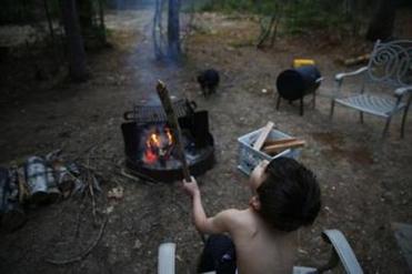 On a warm summer evening Strider sat beside a campfire with a stick as night began to fall.
