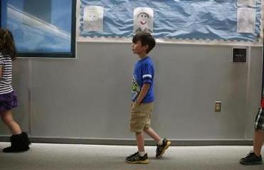 Strider made his way through the hallway of his elementary school as he and his classmates returned from recess.
