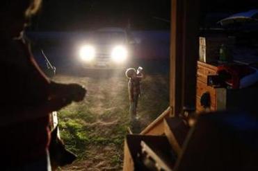 Gallagher cooled off with a drink while Larry and Lanette packed for hours by the light of their car headlights following eviction. The landlord had cut the power and put locks on the electrical boxes in an attempt to force them off the property.