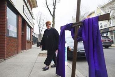 Wendy patrolled the sidewalk outside Sanctuary, inviting in passersby. Not all welcome the invitation. One passerby takes issue with the cross, snapping a picture of it with her smartphone and confronting Wendy about a permit. The interaction came on a difficult day for Wendy, when she felt nothing but roadblocks all around her.