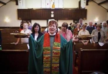 Rev. Wendy Miller Olapade led the congregants in prayer and offering before they proceeded to their new storefront space two blocks away.