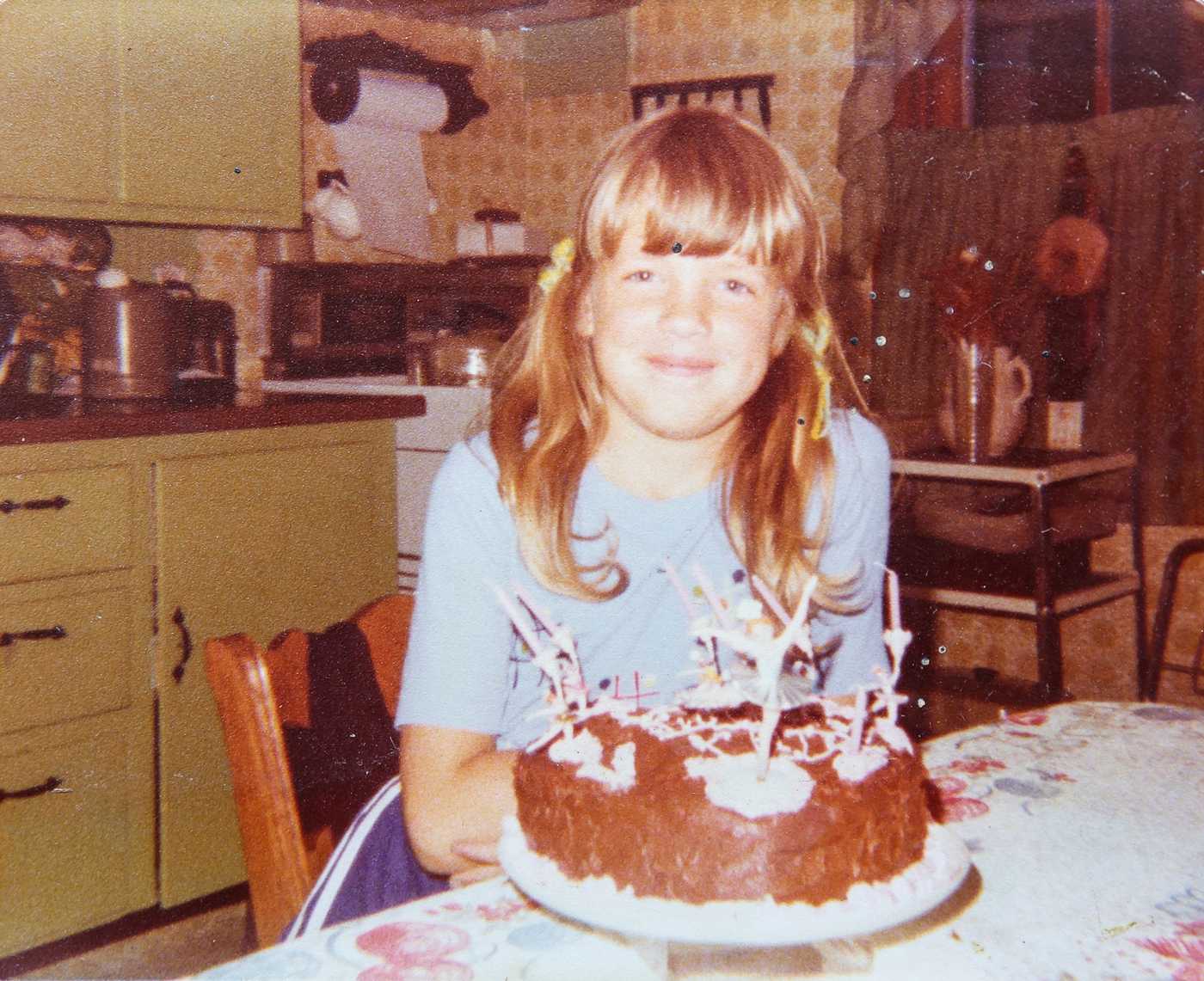 Kate smiles in front of the birthday cake her mother made her for her 10th birthday. 
