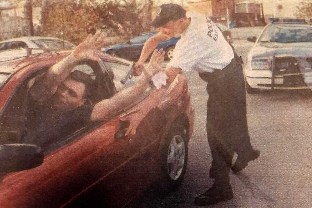 At age 16, in 2002, Matthew Farwell posed for a photo holding a replica weapon while demonstrating a traffic stop with Robert Devine.