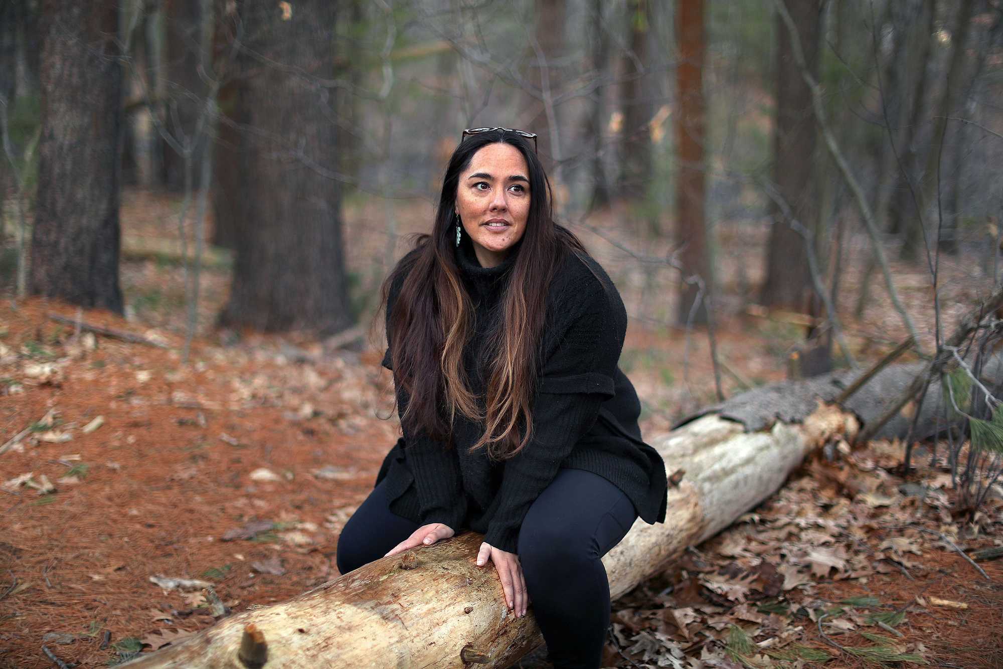 Nicole O’Neil sat on a downed tree on a trail in Woburn near her home that she likes to walk and unwind. 