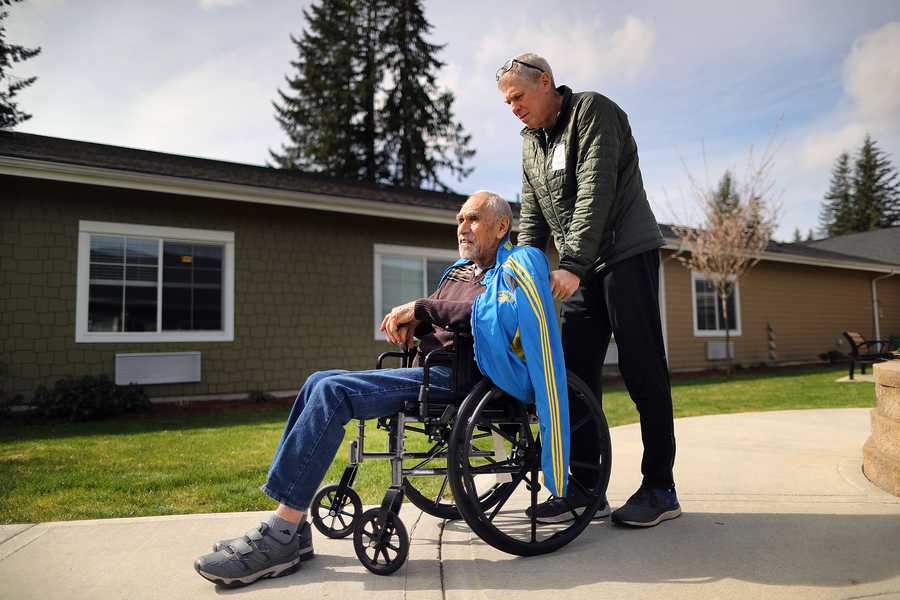 Mark Iffrig pushed his father around the courtyard of Fieldtone Memory Care where he lives. 