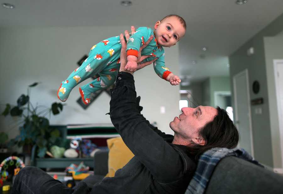 Andrew White  played with his son Waylon, 9 months on the couch in his living room. His parents and brother were injured in the marathon bombing.