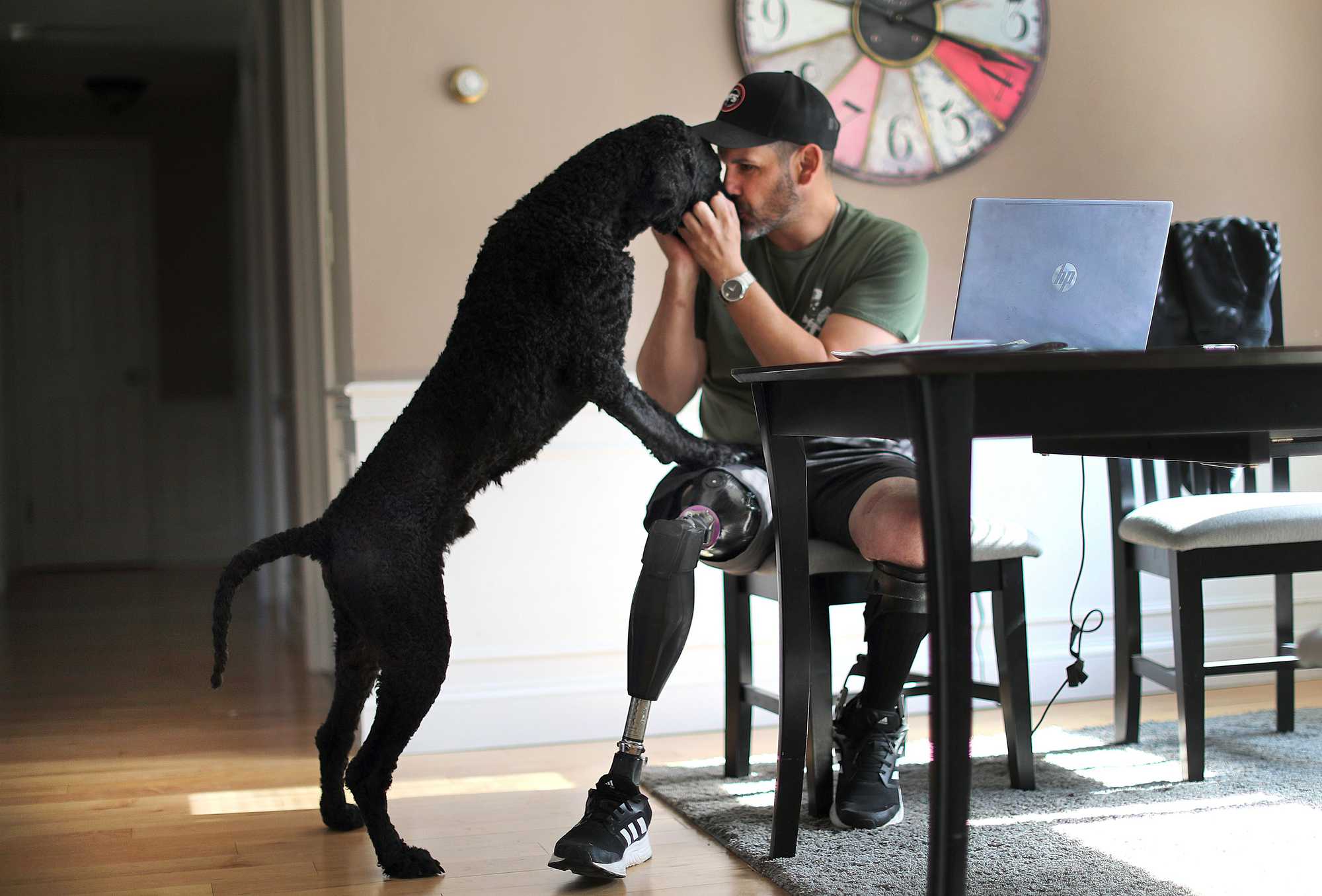 Marc Fucarile kissed his support dog, Onyx, as he worked on his laptop at the kitchen table in Reading. 