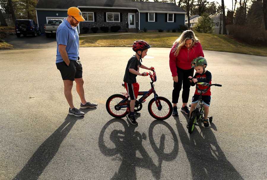 Donohue, 43 (left) and his wife, Kim, (right) helps their sons Connor,6 (left) and Finn, 4 on their bikes win their street. 