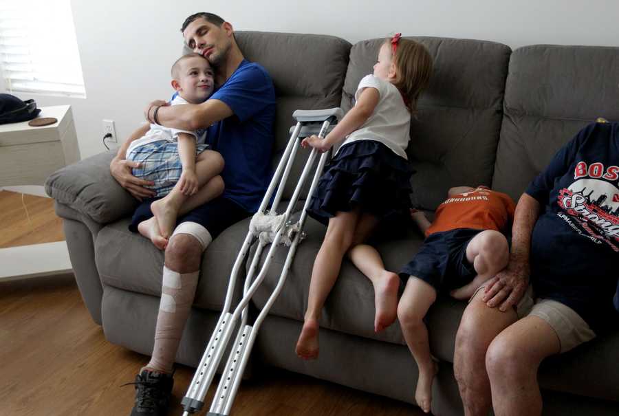 Reading, MA 7-24-13 - Boston Marathon bombing victim Marc Fucarile (cq) hugs son Gavin (cq) after arriving home to a family party following an extended hospital and rehab stay. He is the last victim to leave a hospital following the attack. (Globe staff / Bill Greene) section: metro, reporter:schweitzer, topic: fucarilehome