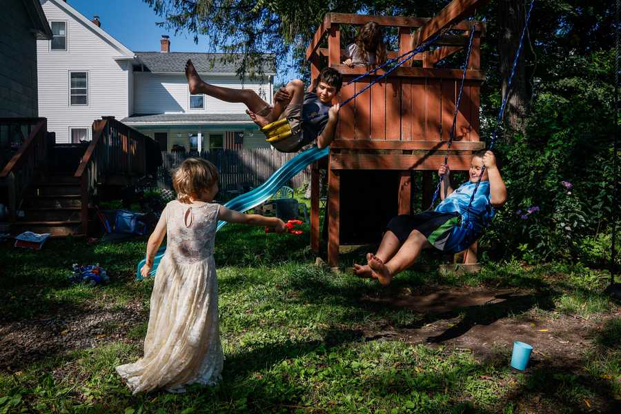 NORTH BROOKFIELD, MA - 9/1/2023 Andrew Boucher, center, 14, swings in his backyard with his siblings Austin, left, and Raymond, after getting home from school on Friday. Boucher, who just started 9th grade, is reading at a 4th grade level.  Erin Clark/Globe Staff LITERACY 