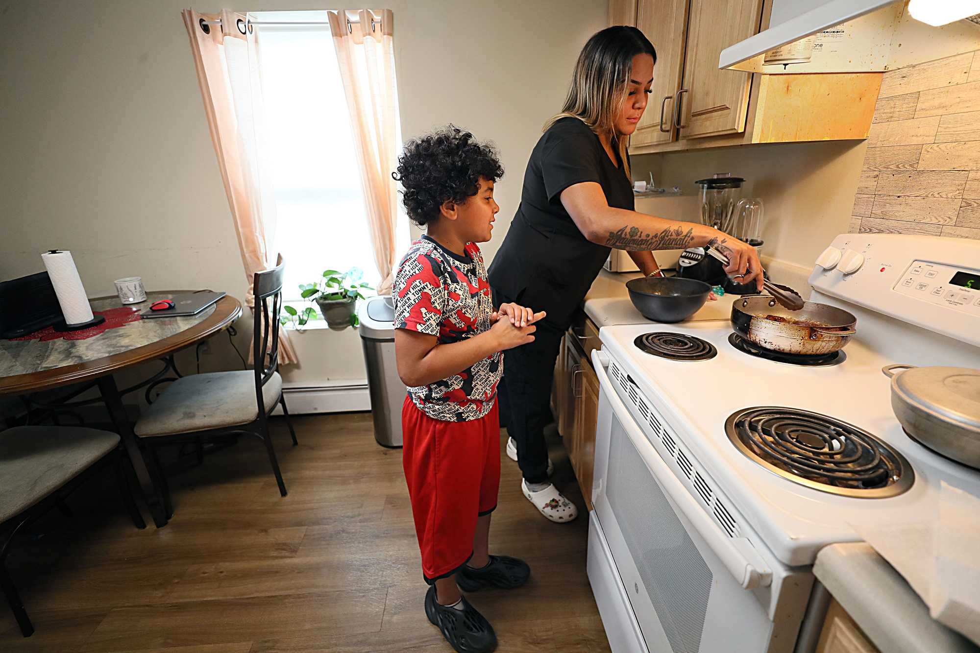 Gardenia Osorio and her 9-year-old son, Isaac, made dinner together in the kitchen of their Lowell apartment.