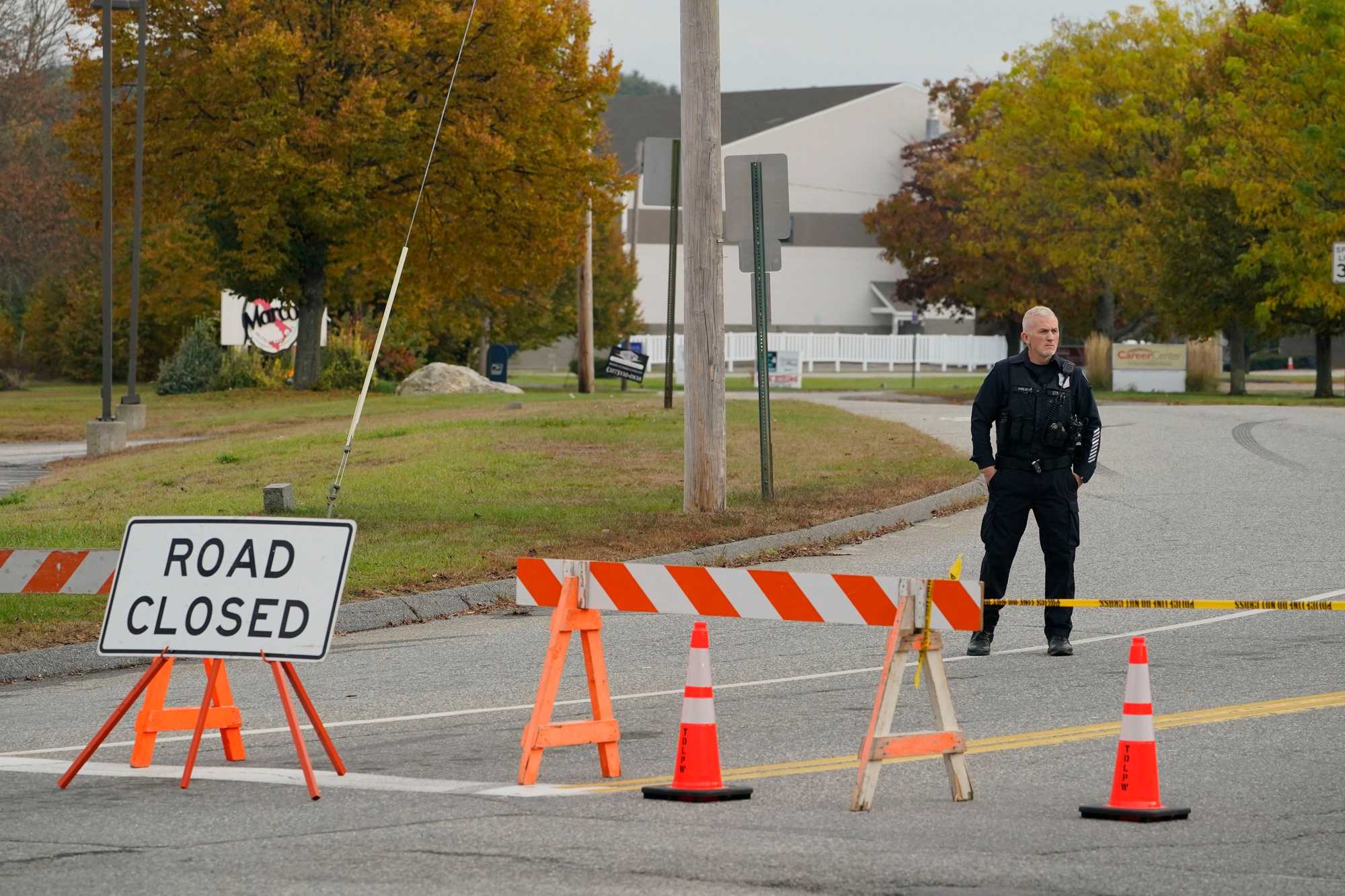 A police officer stood Thursday at a road closure near the bowling alley that was a site of one of the shootings in Lewiston Wednesday.