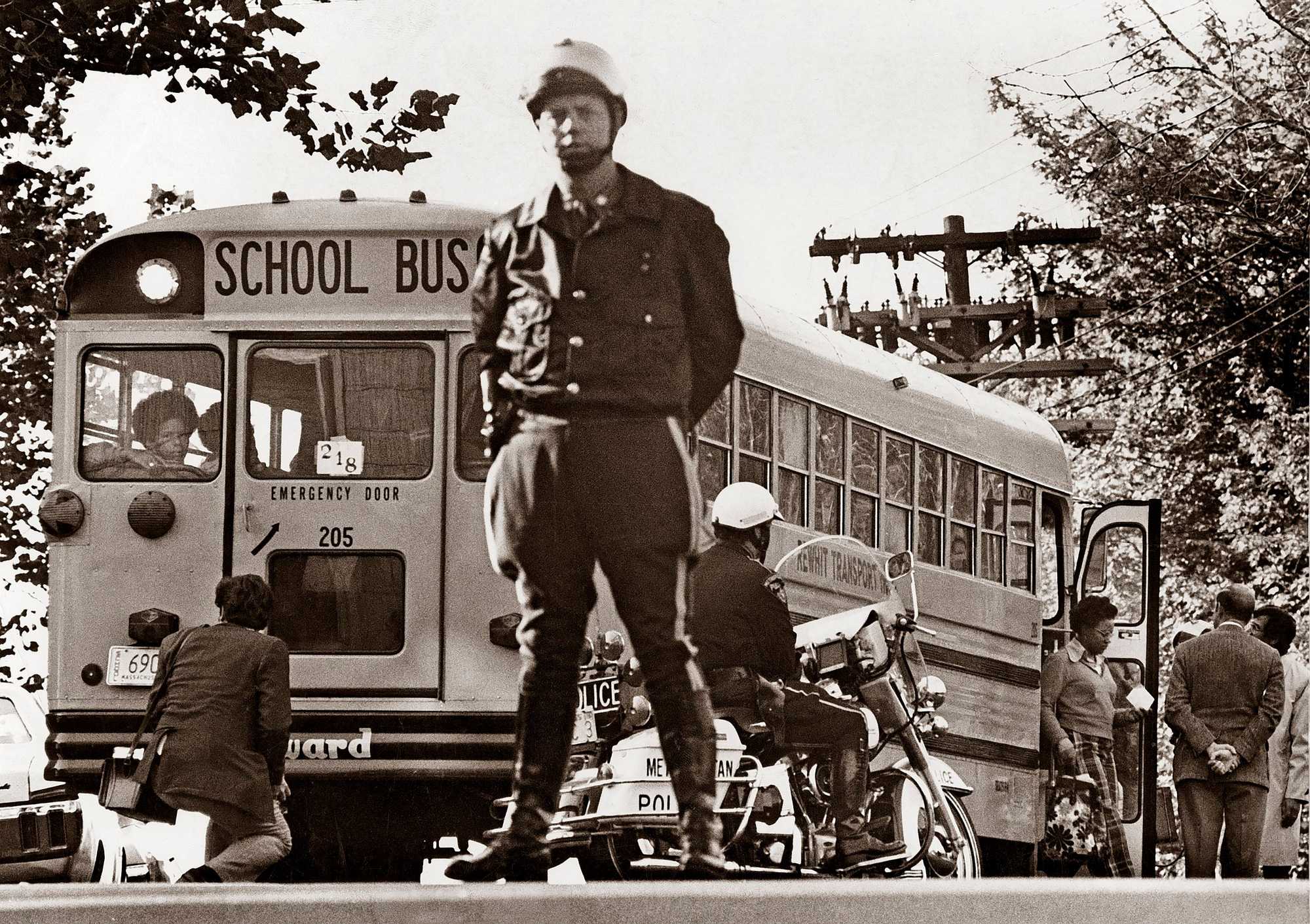 Metropolitan Police officers guarded a school bus outside of South Boston High School on their first day of duty in Boston on Oct. 10, 1974.