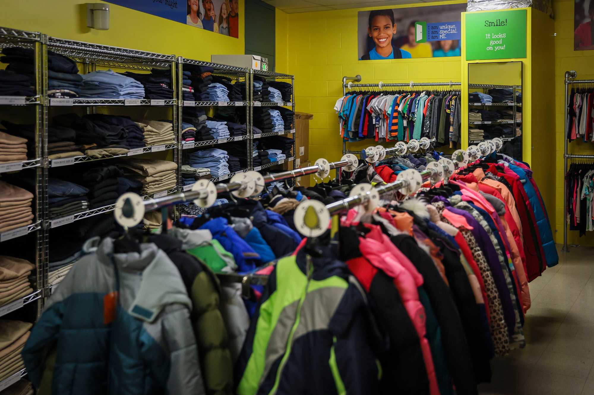 A room at the Lee was filled with racks of new clothing and shelves of home goods, all of it free for school families to take. (Erin Clark/Globe Staff)