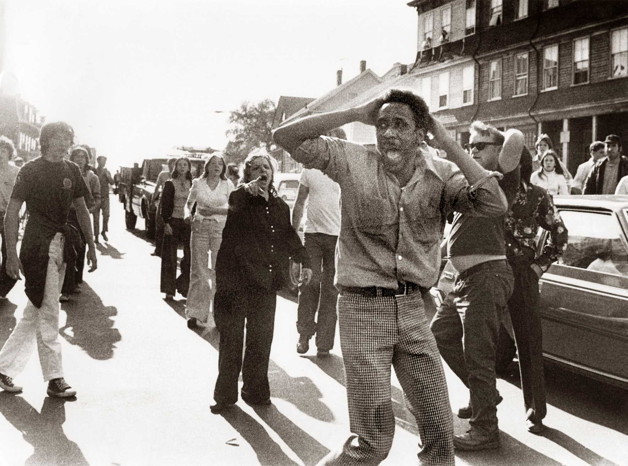 Jean-Louis Andre Yvon stood in the center of a street in South Boston, surrounded by a group of white men and women, on Oct. 7, 1974. Yvon was trying to escape a mob that pulled him from his car as he drove through South Boston.