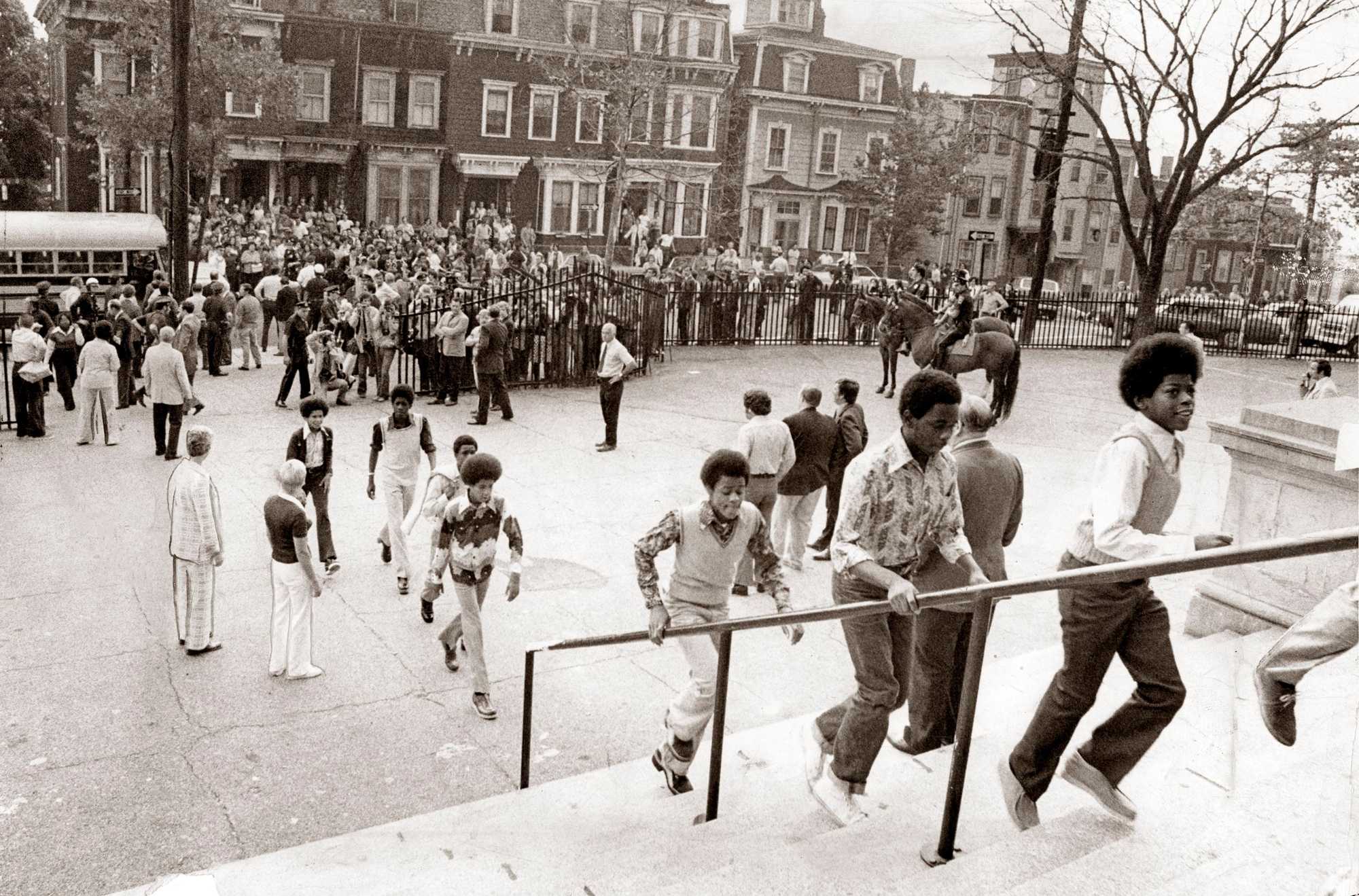 Students made their way to school through crowds in South Boston on the first day of federally imposed desegregation on Sept. 12, 1974. Twenty-thousand students had been assigned to buses for rides, ranging from a few blocks up to three miles to newly integrated schools in the largest school busing program in the city's history. 
