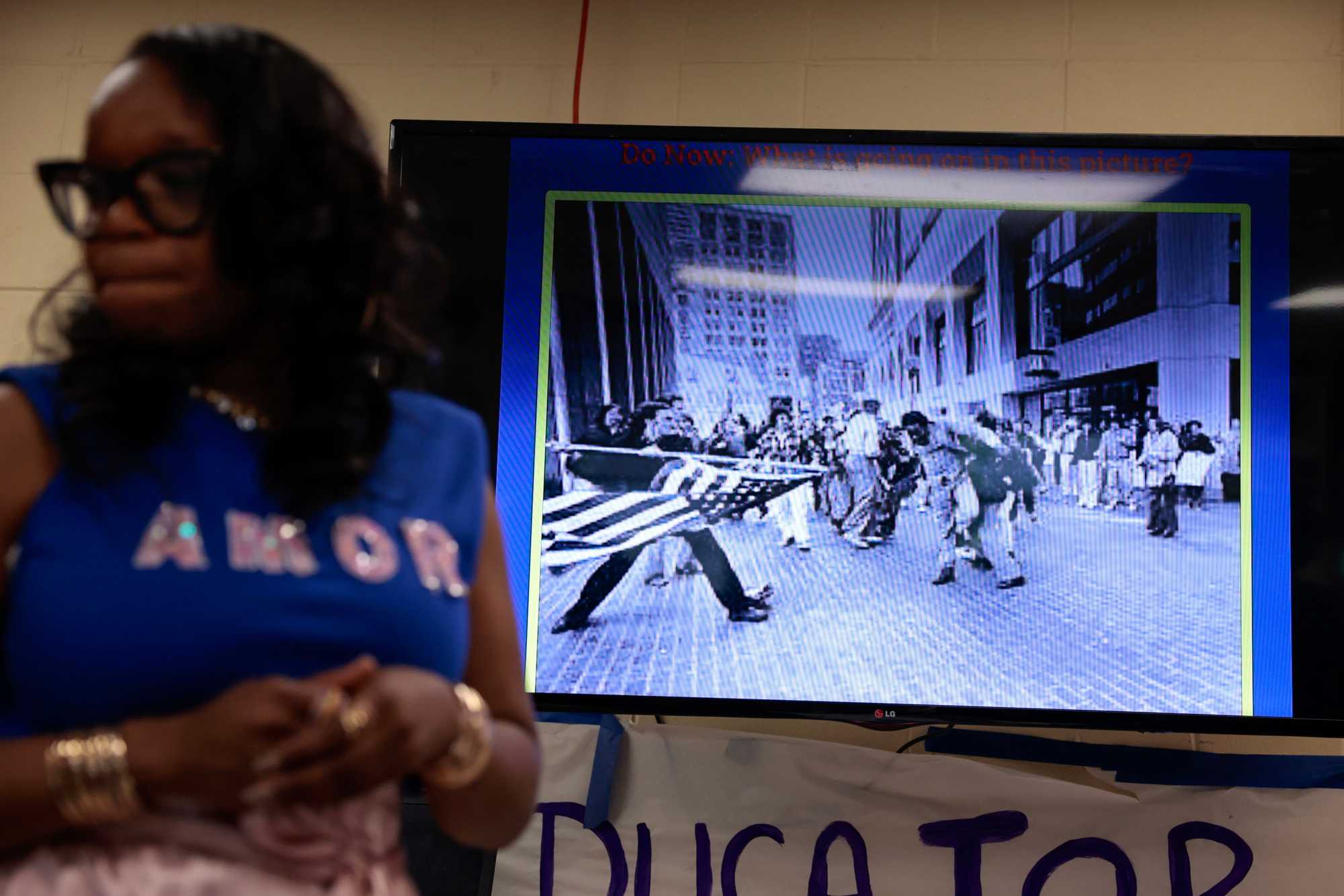Tanisha Milton displayed a Pulitzer Prize-winning photo by Stanley Forman during a lesson on busing and the desegregation of Boston Public Schools in her eighth-grade civics class at TechBoston Academy in Dorchester in May. 