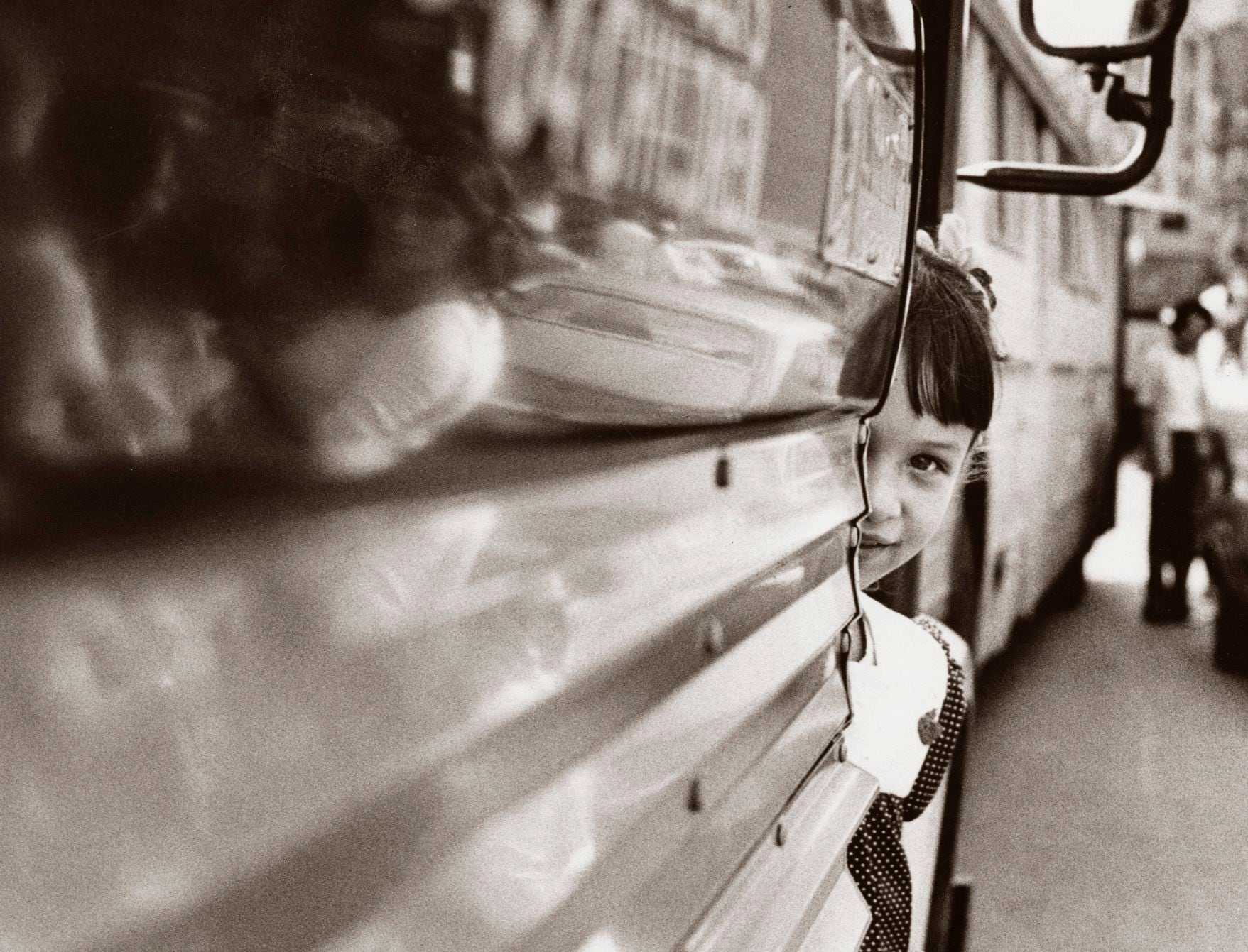 A Spanish-speaking girl peeked around the door of a bus at Lincoln School in Bay Village in Boston on Sept. 13, 1974, the second day of school under the new busing system put in place to desegregate Boston Public Schools. 