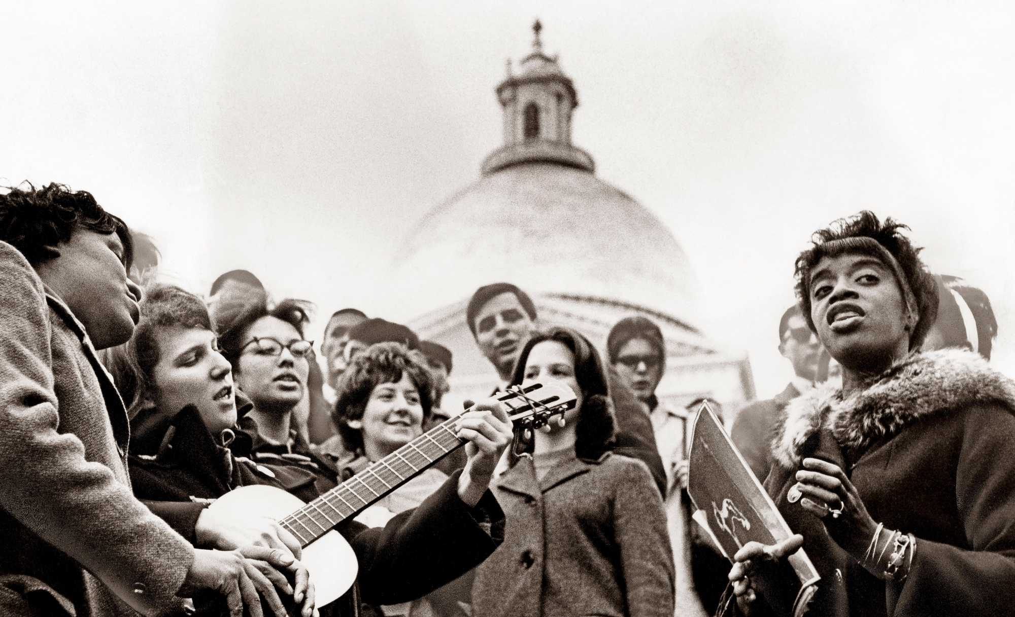 Students sang songs on the Boston Common during a Freedom School event, with the State House in the background on Feb 26, 1964. (Paul Connell/Globe Staff) 