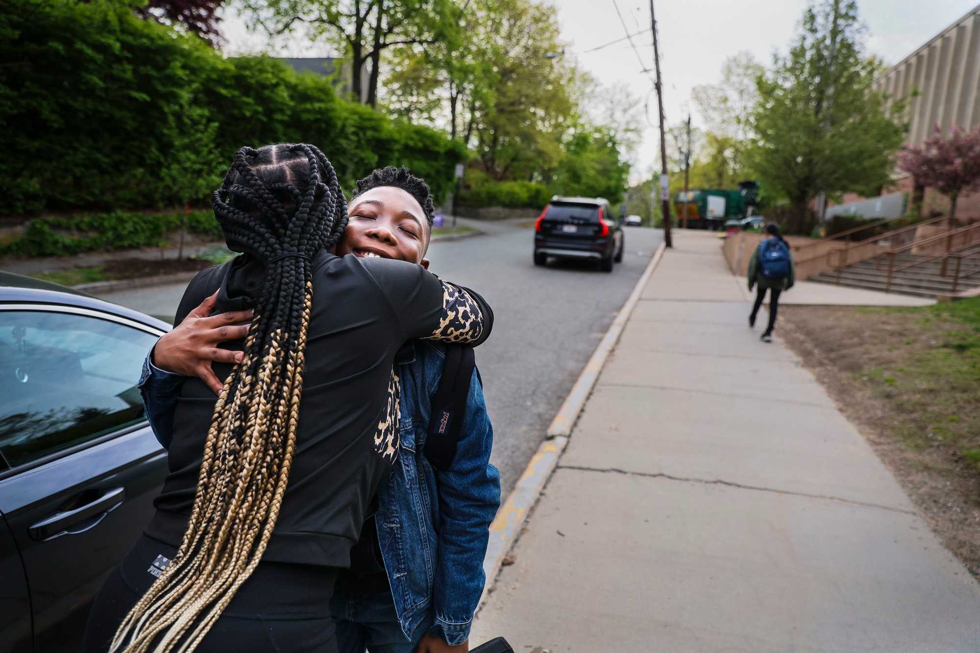 Kueen King hugged Tavaj after dropping him off at a Newton public school. (Erin Clark/Globe Staff)

