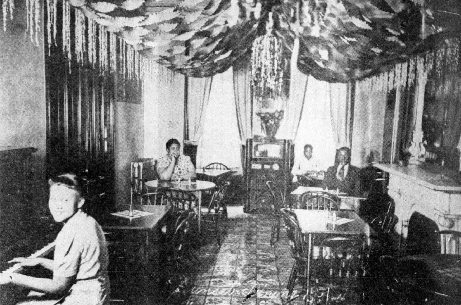 The interior of the Sunset dining room at the Western Lunch Box, with proprietor Mary C. Jackson in the back left. 