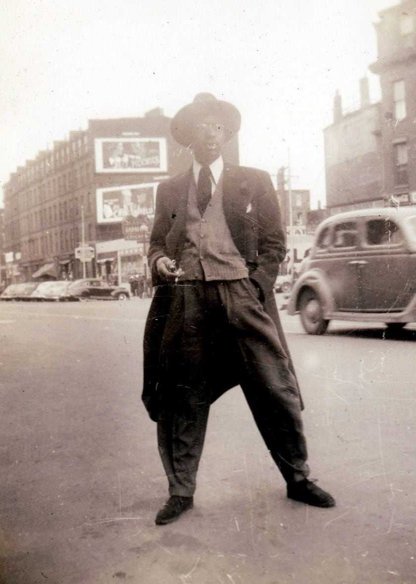 A man posed in front of Slade's barbeque chicken restaurant on Tremont Street 1935-45.