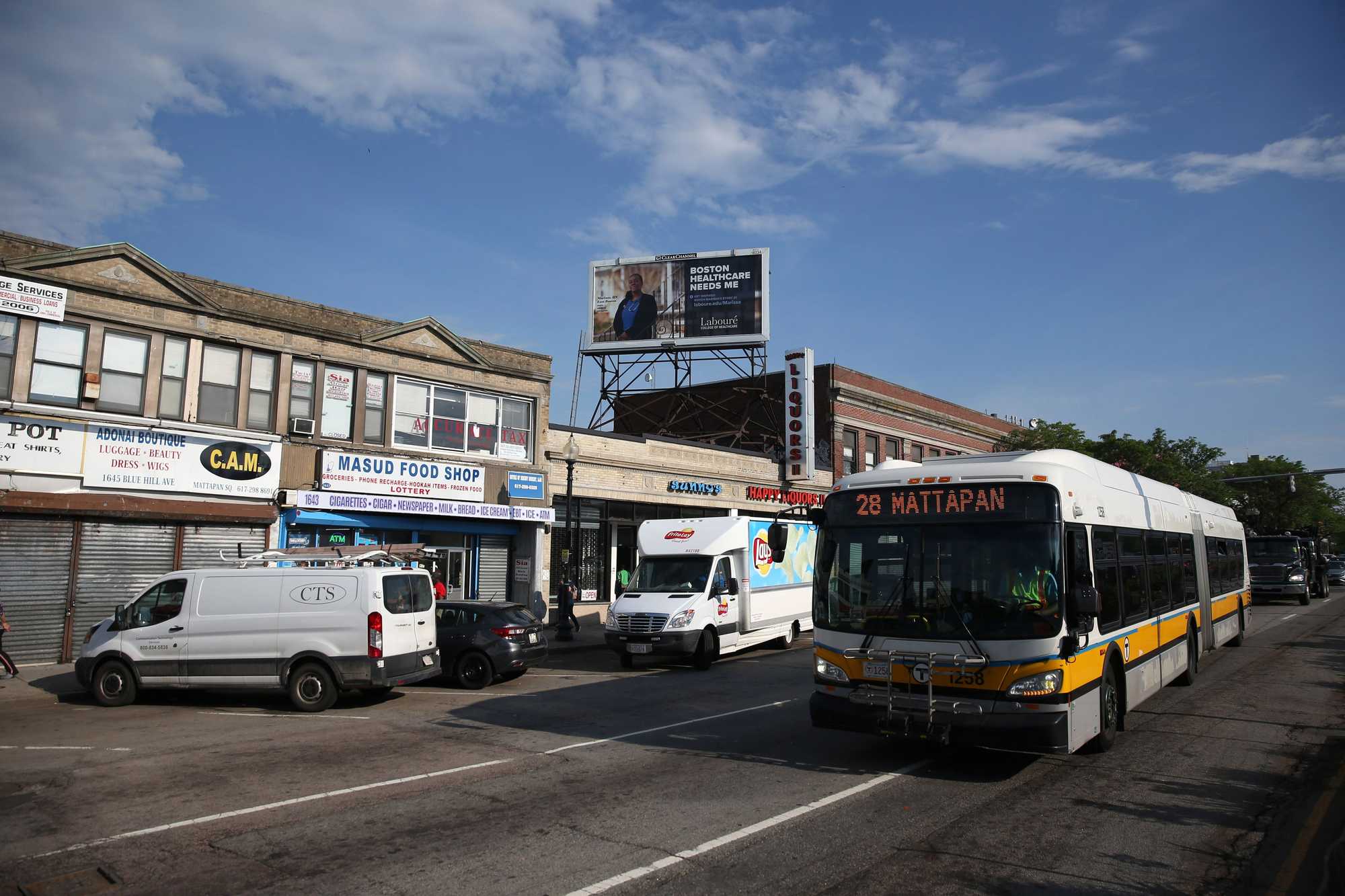 A Number 28 MBTA bus moved through Mattapan Square, along Blue Hill Avenue. 