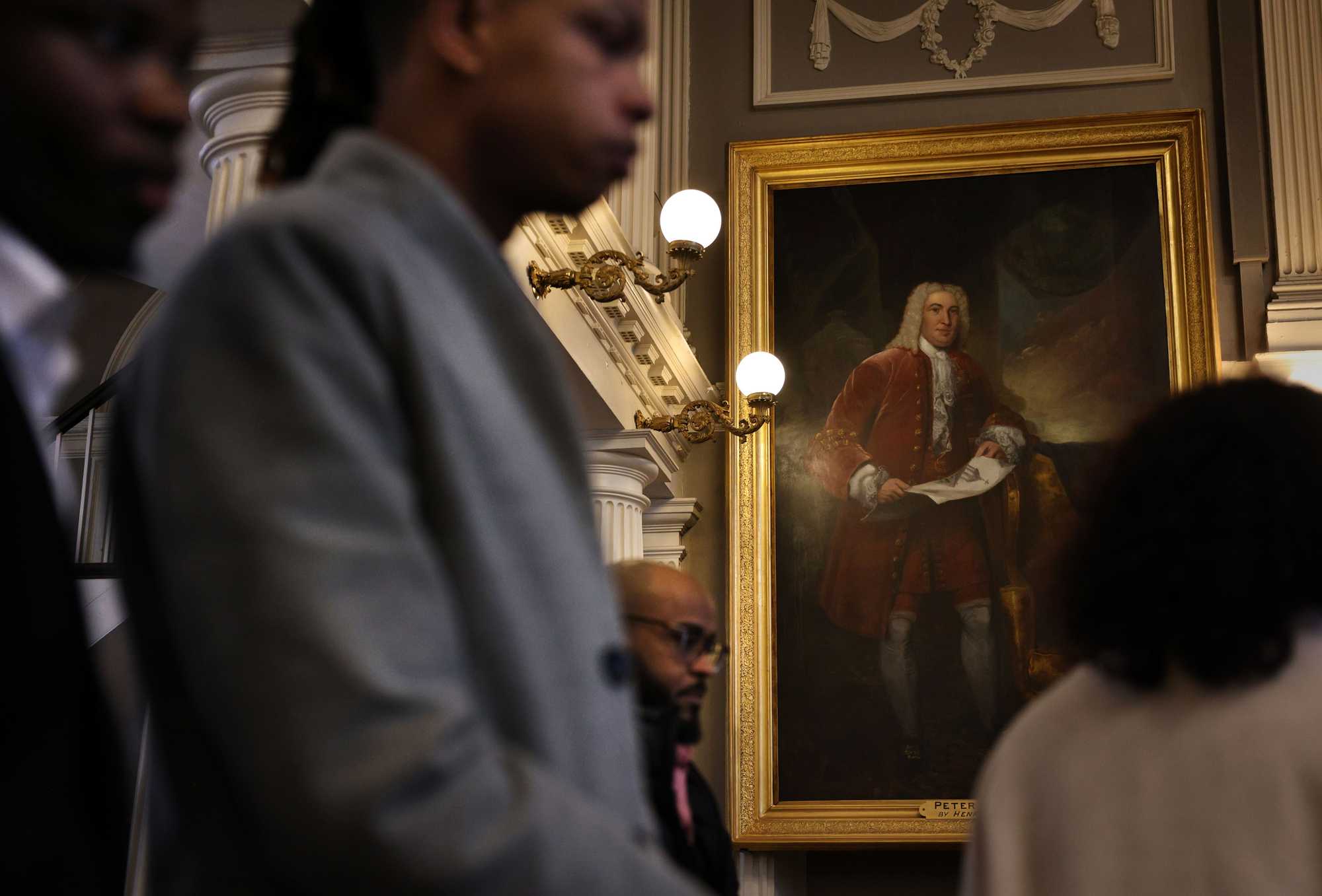 A portrait of Peter Faneuil hangs in the Great Hall during a naturalization ceremony at Faneuil Hall.
