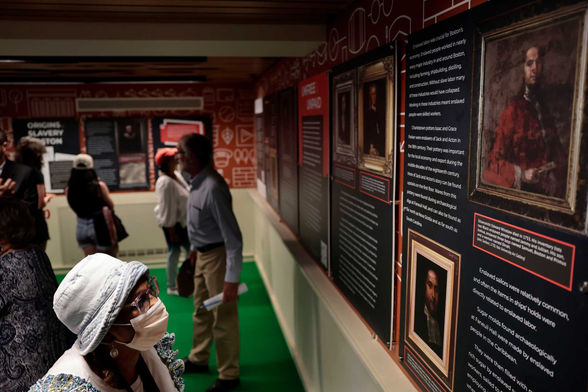 Kathryn Ehrhardt Mathews studied panels during an opening ceremony for a “Slavery in Boston” exhibit at Faneuil Hall on June 16.
