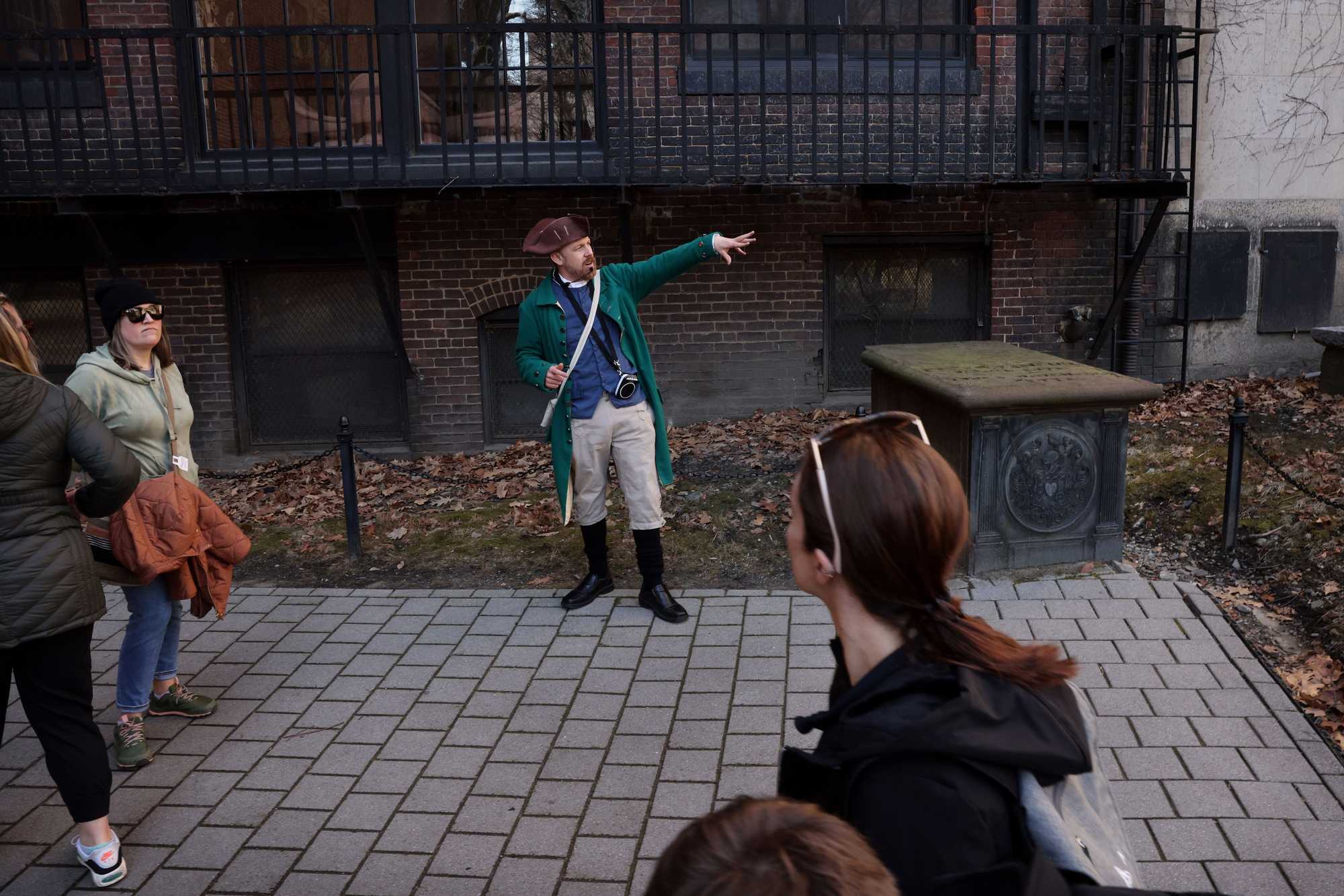 Lucas Milliken, dressed as historic character Harbottle Dorr, stood next to the tomb of Peter Faneuil while leading a tour through the Granary Burying Grounds in Boston.


