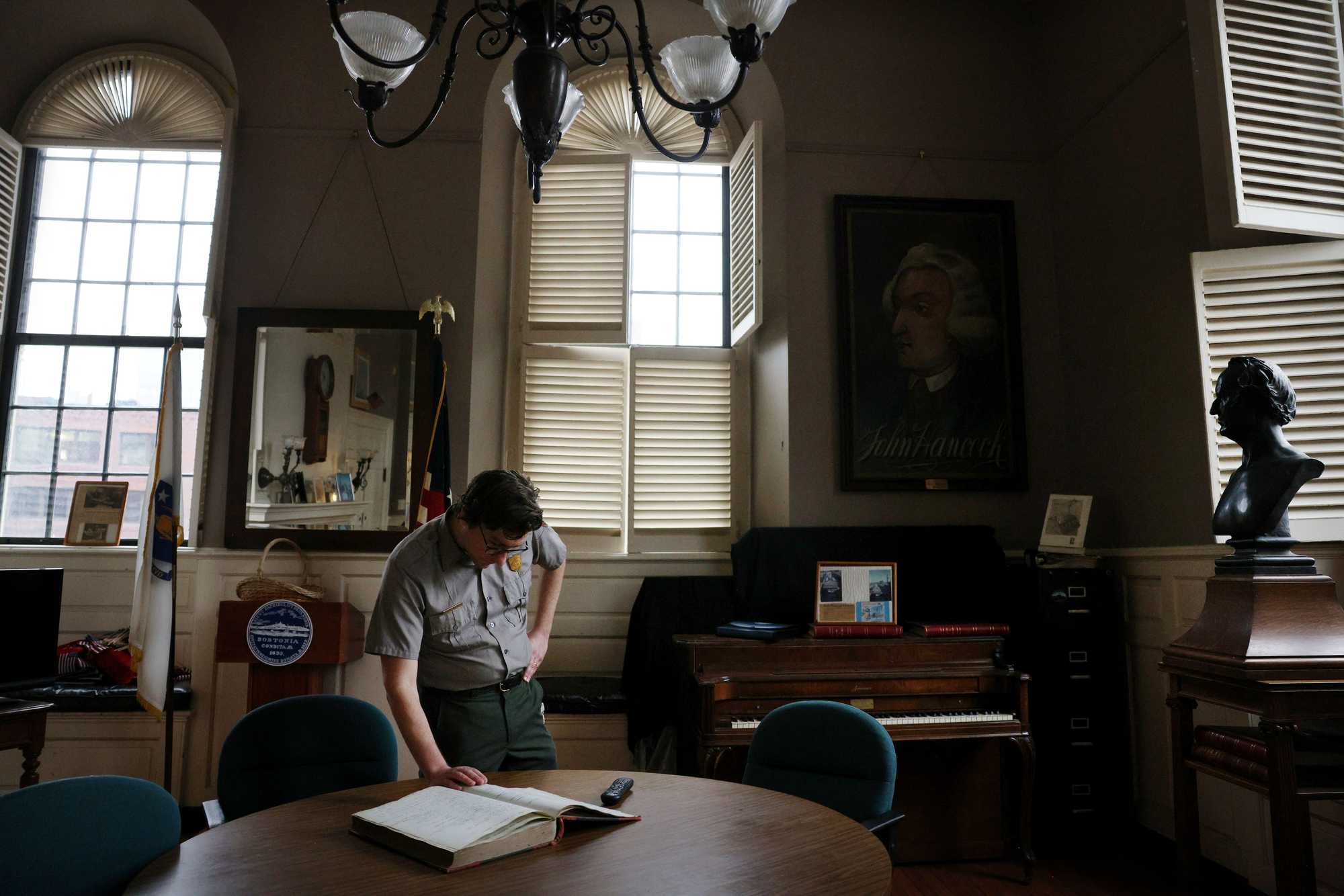 Eric Hanson Plass of the National Park Service had served as the lead ranger at Faneuil Hall. In the old city superintendent's office at Faneuil Hall, he displayed a guest book; at right is a bust of abolitionist and orator Wendell Phillips. 