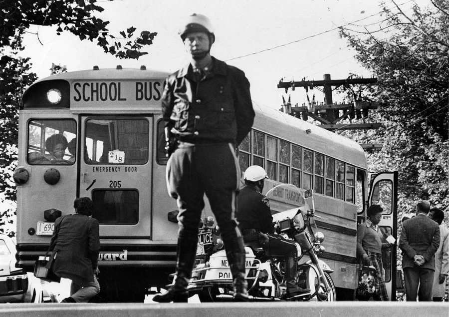 Mass. State Police and Metropolitan District Commission Police officers guarded a school bus outside of South Boston High School on Oct. 10, 1974. The initiative to desegregate Boston Public Schools was met with strong resistance from many residents of Boston's neighborhoods. (Ted Dully/Globe Staff) 