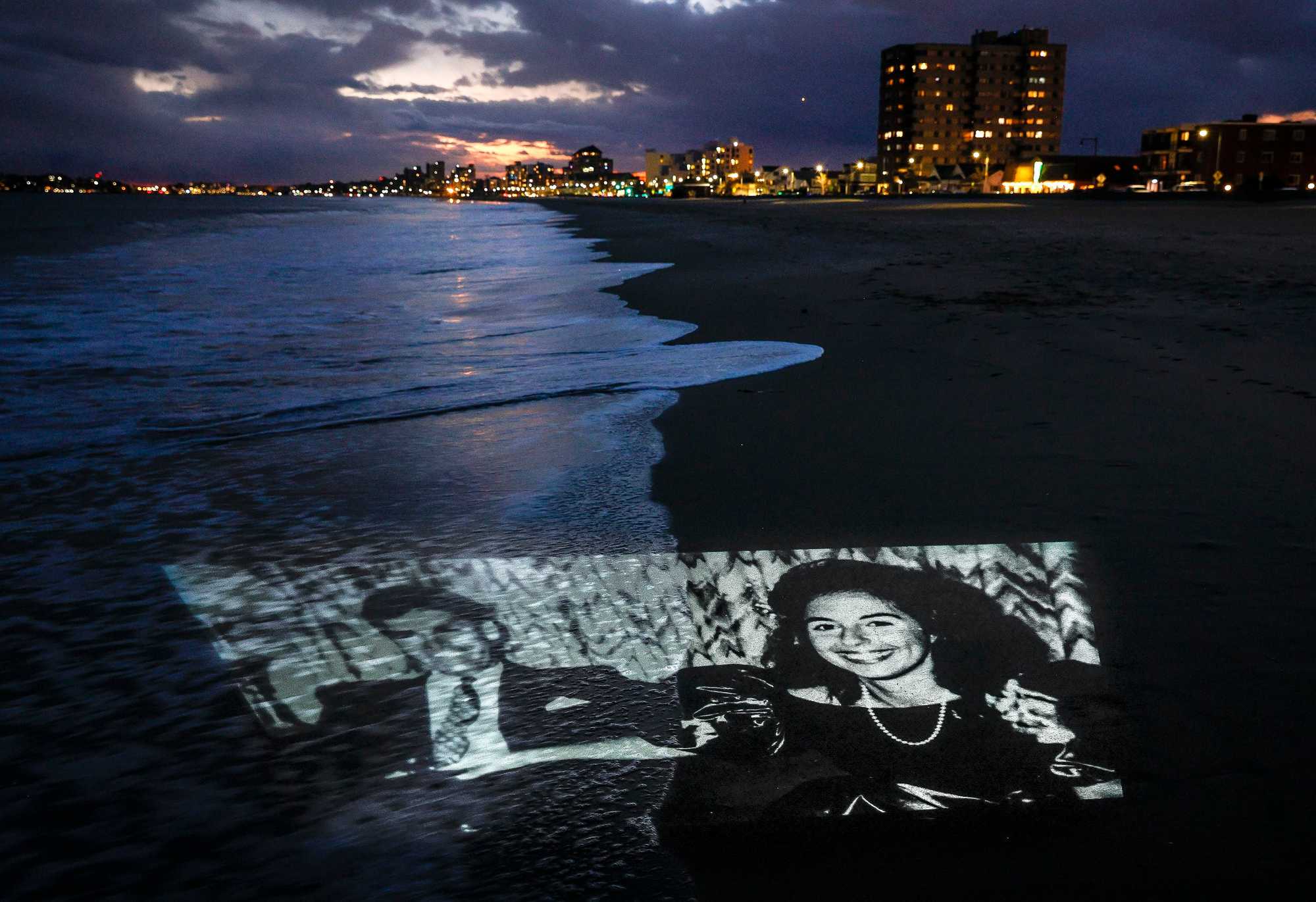 A photo of Charles and Carol Stuart is projected on Revere Beach, near where the pair met at the former site of the Driftwood restaurant on Revere Beach Boulevard. 