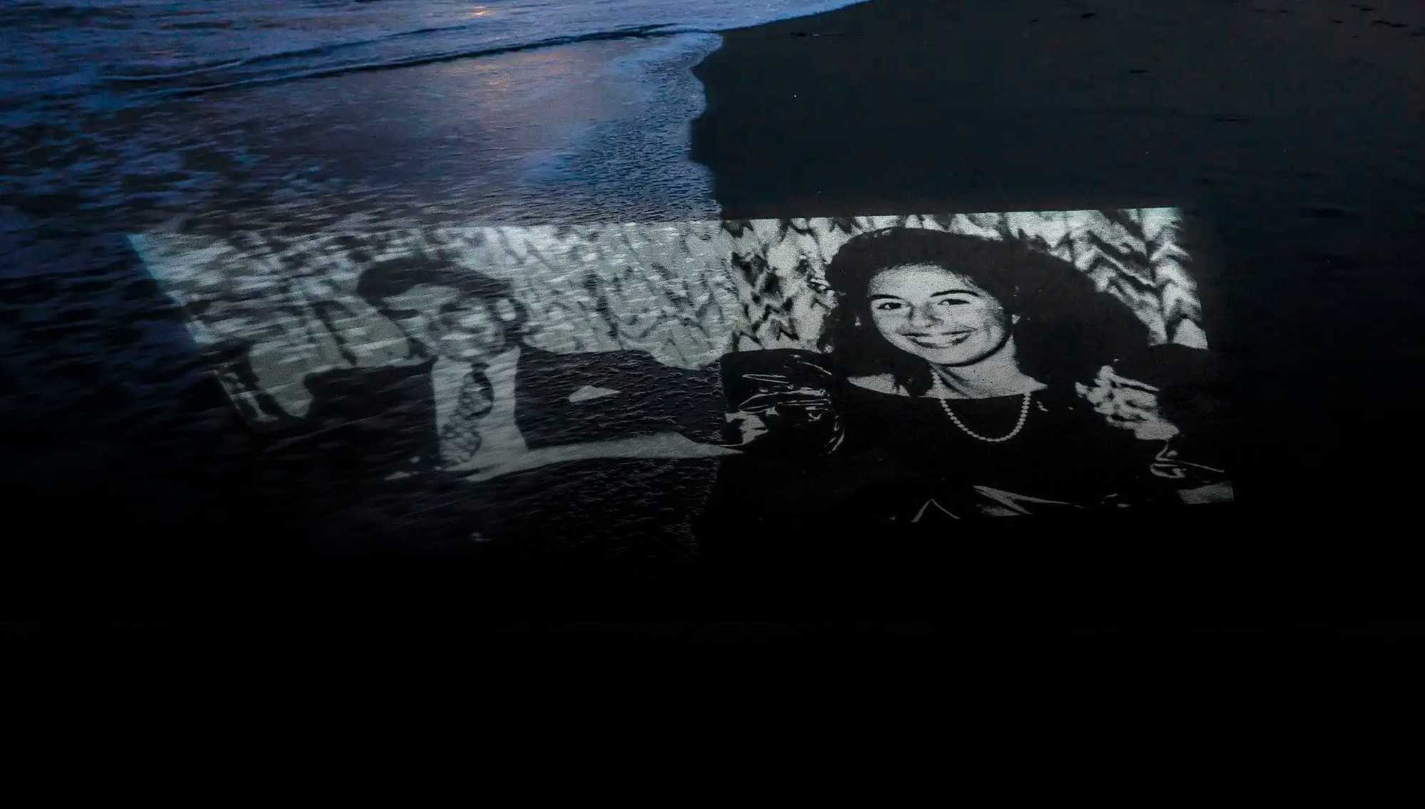 A photo of Charles and Carol Stuart is projected on Revere Beach, near where the pair met at the former Driftwood restaurant on Revere Beach Boulevard. 